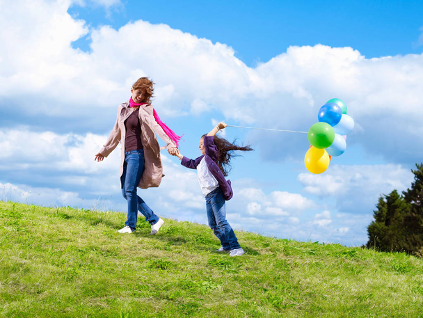 Mother & daughter with balloons in wind - Фото, зображення