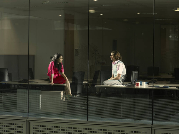 Two people sitting in an office - Фото, изображение