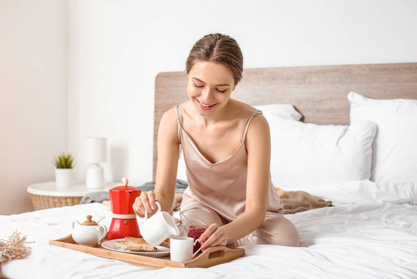 Morning of beautiful young woman having breakfast in bed - Foto, imagen