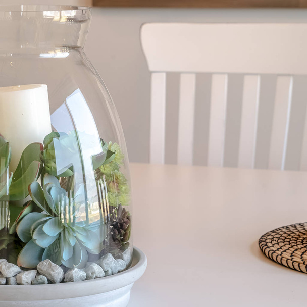 Barattolo di vetro decorativo con piante e candela sul tavolo da pranzo di casa
 - Foto, immagini