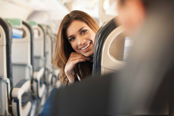 Female passenger turning around on aeroplane - Photo, Image