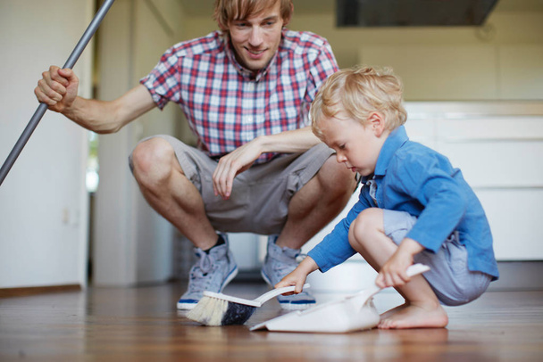 Boy helping father sweep floor - Valokuva, kuva