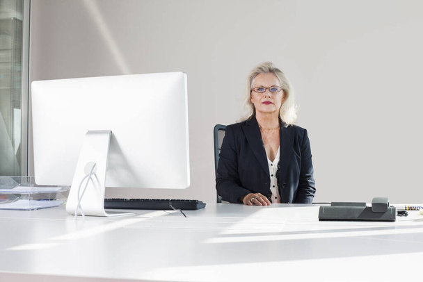 Businesswoman at desk, portrait - Foto, Bild