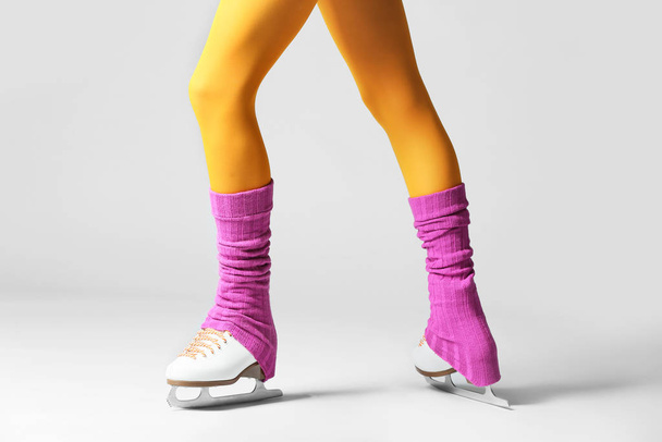 Young woman in ice skate shoes on grey background - Photo, Image