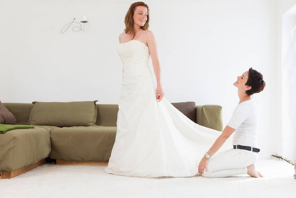 Designer fitting wedding gown on client - Valokuva, kuva