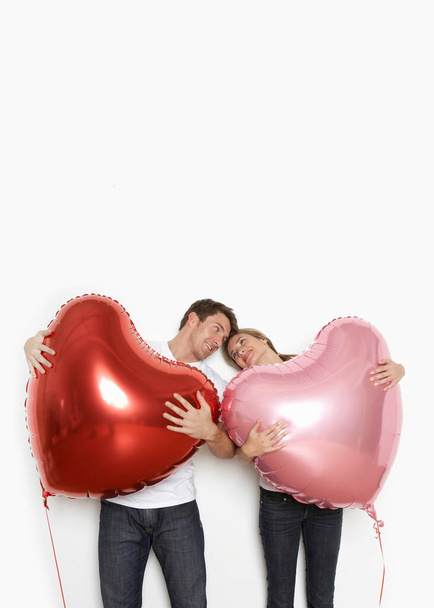 Couple holding heart balloons - Foto, afbeelding