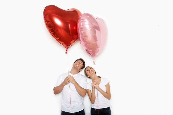 Couple holding up heart balloons - Foto, Bild