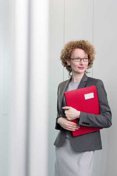 Portrait of businesswoman holding red file - Valokuva, kuva
