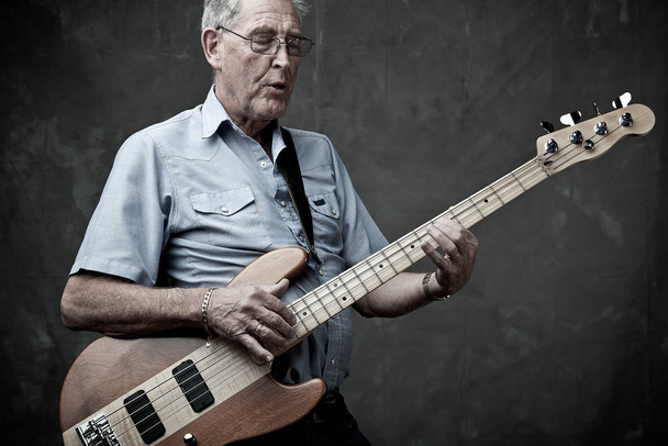 Senior man playing bass guitar - Foto, Imagen
