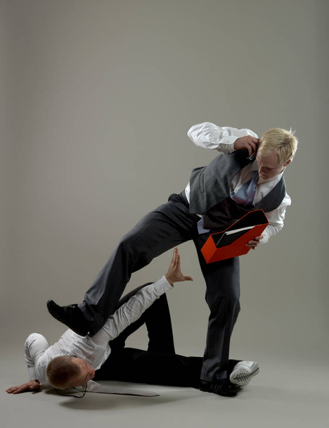 Business man fighting over paper holder - Foto, afbeelding