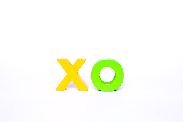 Жовта літера X і зелена літера O. Ізольовані дерев'яні літери алфавіту. Листи утворюють емоційну форму XO-конфесії
. - Фото, зображення