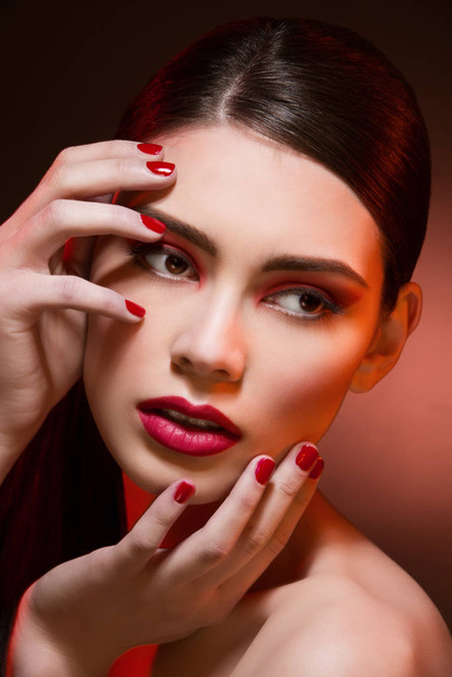 Closeup portrait of beautiful young woman with bright red eyeshadows, lips and nails - Fotoğraf, Görsel