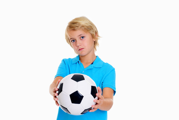 blond boy with soccer ball in front of white background is not happy - Fotografie, Obrázek