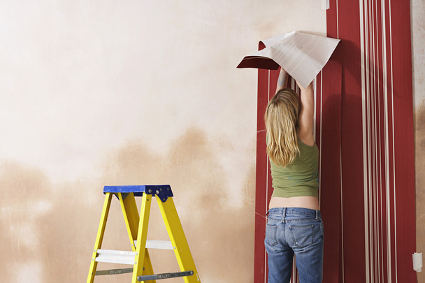 Young Woman Wallpapering - 写真・画像