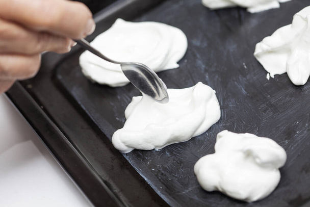 Meringues preparation : placing and shaping meringues on a baking sheet - 写真・画像