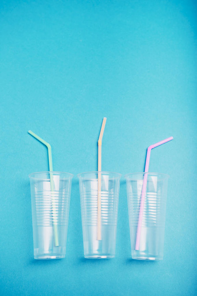 Empty plastic cups with colorful straws - Foto, afbeelding