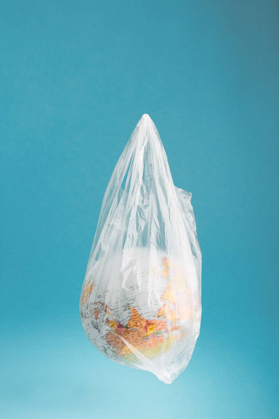 Globe in a plastic bag. Earth contaminated by plastic waste - Photo, Image