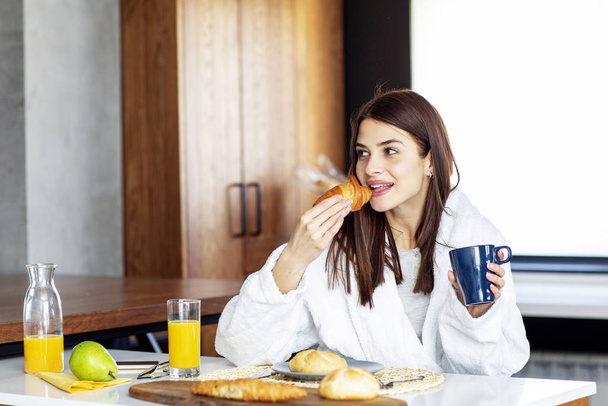 Woman with breakfast in the kitchen in morning - Fotografie, Obrázek