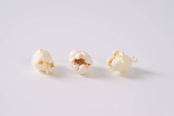 three pieces of fresh popcorn on white background - Фото, зображення