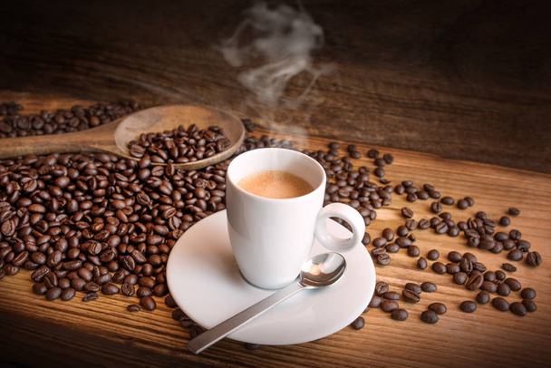 cup of coffee and beans on dark wooden background - Foto, imagen