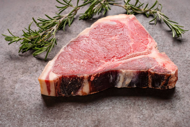 raw dry aged steak and ox chop with rosemary - Foto, afbeelding