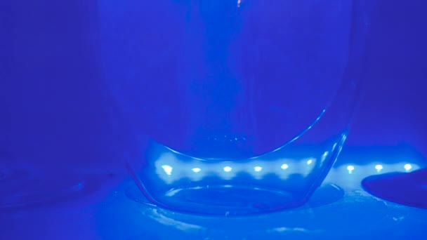 La pilule tombe en verre avec de l'eau et se dissout, fond de couleur bleue, concept de soins de santé
 - Séquence, vidéo