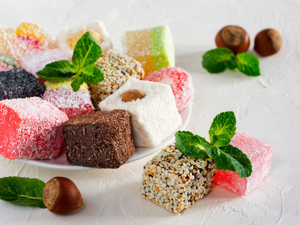 Turkish delight on white rustic background. Turkish deligh set. Assorted traditional turkish delight on oriental background - Photo, image