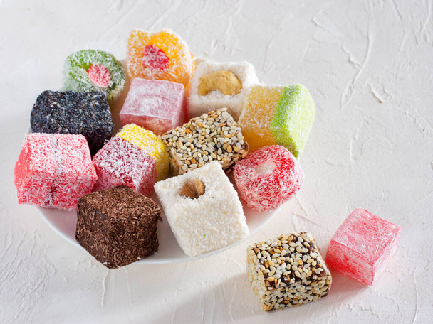 Turkish delight on white rustic background. Turkish deligh set. Assorted traditional turkish delight on oriental background - Фото, изображение