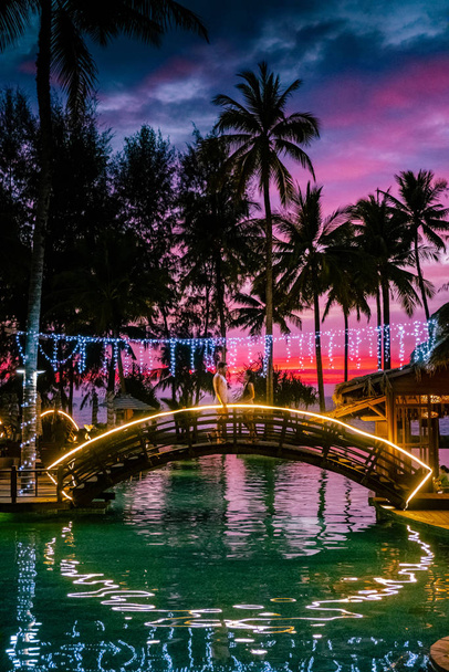 coppia che guarda il tramonto sulla spiaggia e la piscina di un resort di lusso in Thailandia Khao Lak
 - Foto, immagini