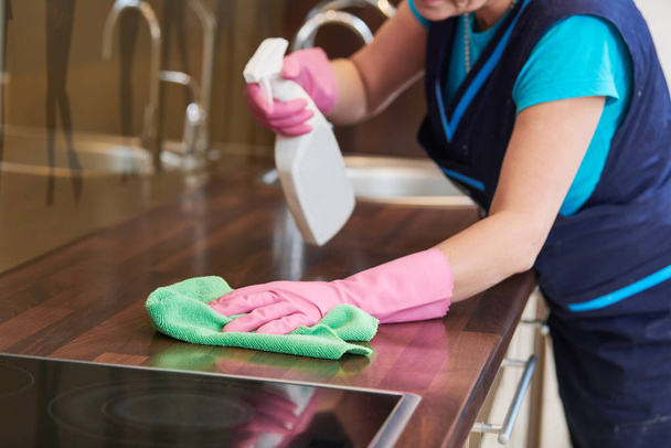 servicio de limpieza. limpiando el gabinete de cocina con tela y líquido
 - Foto, Imagen