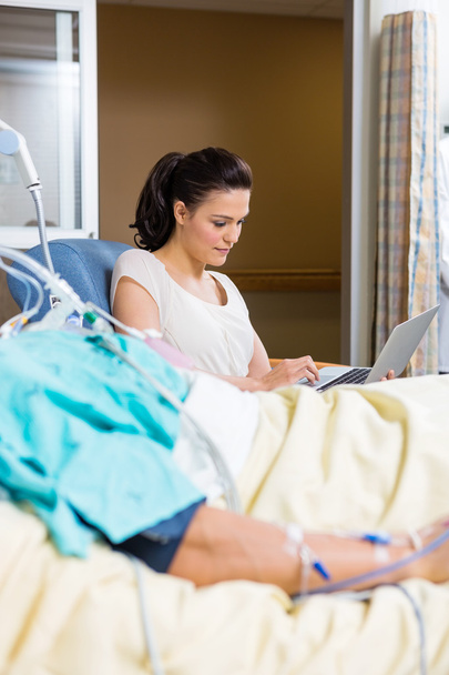 Woman Using Laptop While Sitting By Patient - Foto, immagini