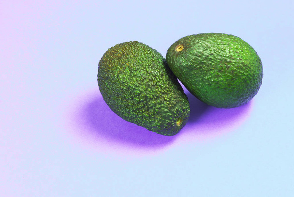 Ein paar frische Avocados vor violettem Hintergrund.   - Foto, Bild