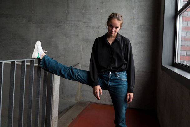 Fiatal nő lábakkal a lépcsőn Korlát Nézi a kamerát - Fotó, kép