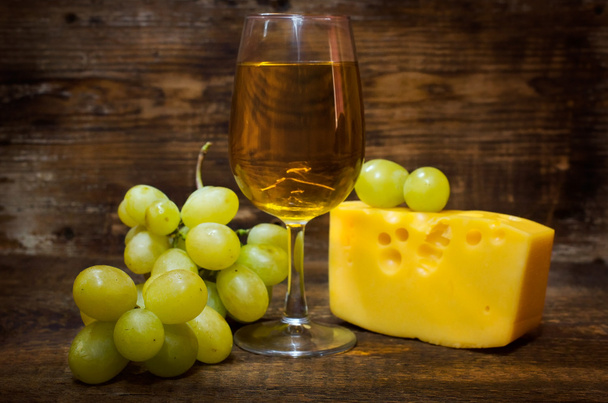 still life with white wine , cheese and grapes - Photo, Image