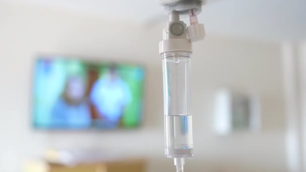 Detailní záběr solného roztoku kapačka pro pacienta a infuzní pumpa na rozmazané luxusní Vip pokoj pozadí v nemocnici. - Záběry, video