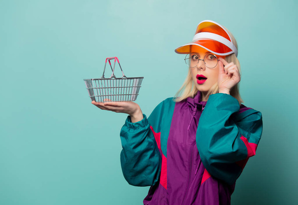 Estilo mujer rubia en traje deportivo de los años 90 con cesta de la compra
 - Foto, Imagen