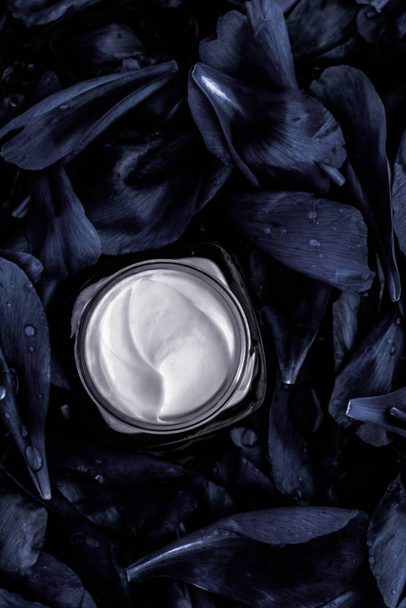 Crème hydratante visage de luxe pour la peau du visage sur bac fleur sombre
 - Photo, image