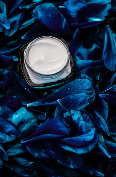 Κρέμα προσώπου πολυτελείας για το δέρμα του προσώπου σε μπλε bac λουλούδι - Φωτογραφία, εικόνα
