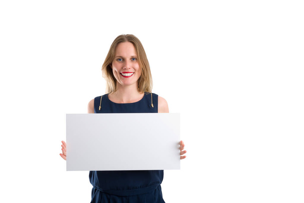 Smiling blonde woman holding a blank white board to present something, isolated on white - Valokuva, kuva