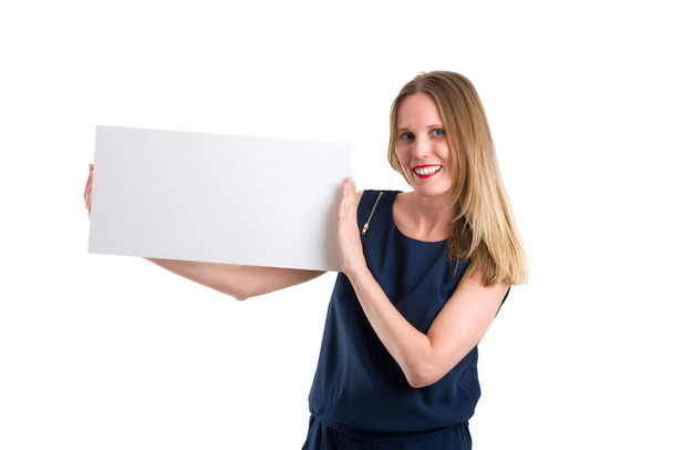 Smiling blonde woman holding a blank white board to present something, isolated on white - Fotografie, Obrázek