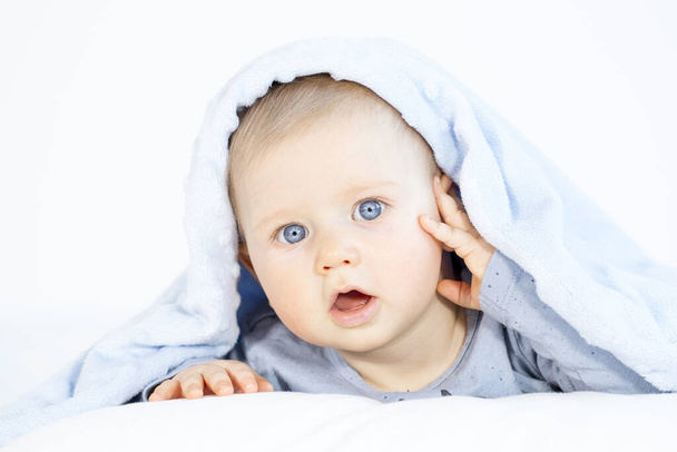beautiful baby boy lying in bed on white background - 写真・画像