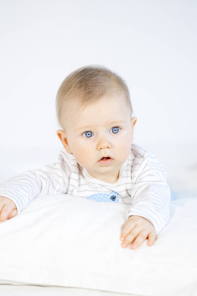 beautiful baby boy lying in bed on white background - Foto, immagini