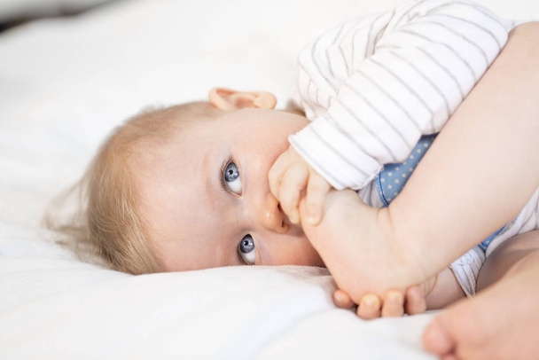 beautiful baby boy lying in bed on white background - Foto, Imagem