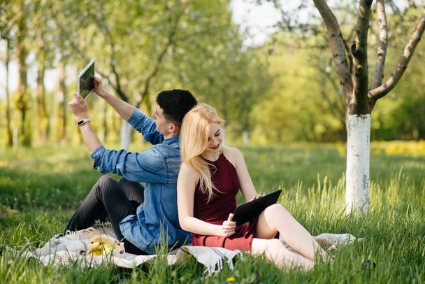 美しいカップルは夏の公園で時間を過ごす - 写真・画像