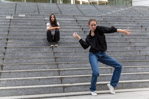 Fiatal nő Tánc és egy másik Ülő Márvány Lépcső - Fotó, kép