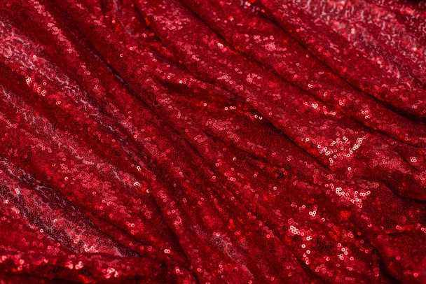 jasně červená tkanina s malými kulatými flitry, s kovovým leskem vyvedeným vlnami na Valentýna - Fotografie, Obrázek