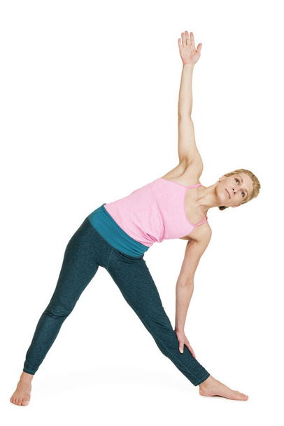 side full body view of a young woman doing yoga exercise \ - Фото, зображення