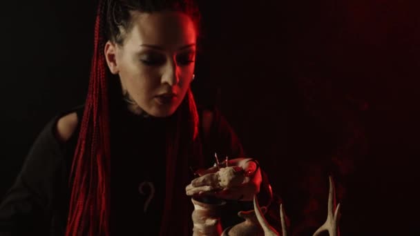 Hexe hält Voodoo-Puppe mit Nadeln und erzählt Zauber - Filmmaterial, Video