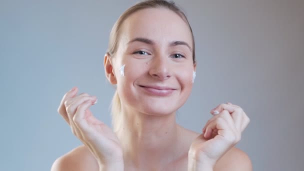 Woman putting on cream on her face. The pursuit of beauty - Filmmaterial, Video