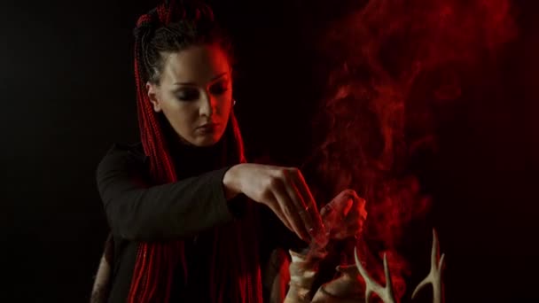 Witch with braids adding ingredients to magic potion - Footage, Video